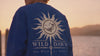 Four friends in Wild Dawn sweatshirts walking down a dock at sunset